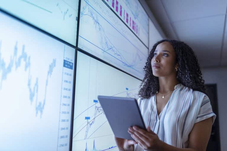 Businesswoman, devant un mur video LCD dans la finance