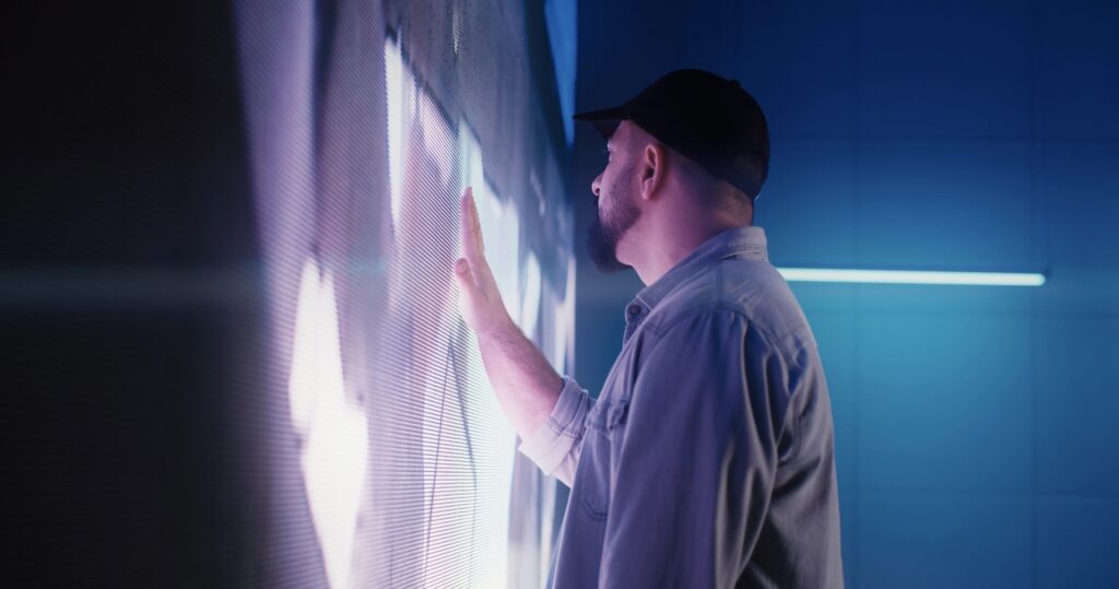 Un homme en train de toucher un écran LED COB