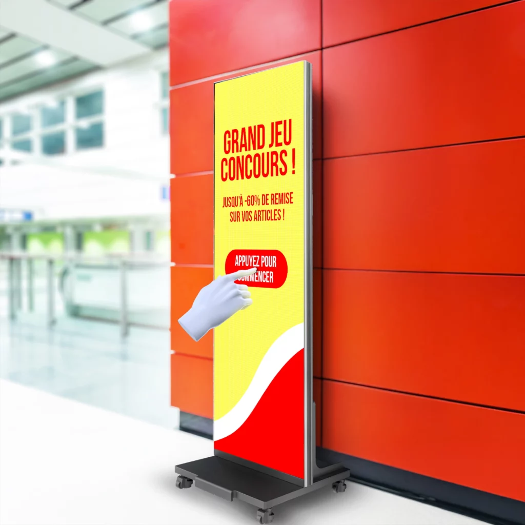 écran totem numérique tactile dans un super maché qui affichE un jeu concours
